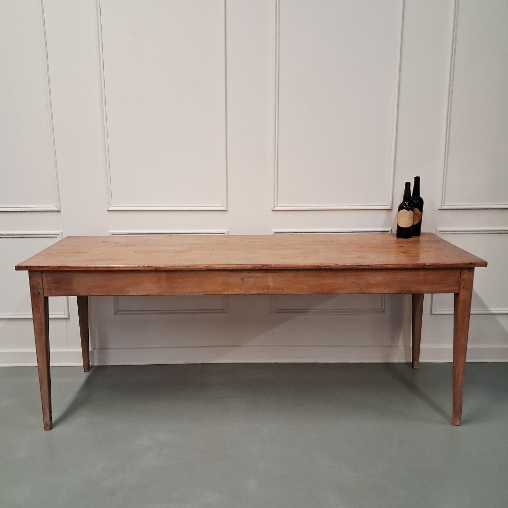 A long antique pine dining table featuring a solid plank top, deep side apron, and four tapered square legs. View II