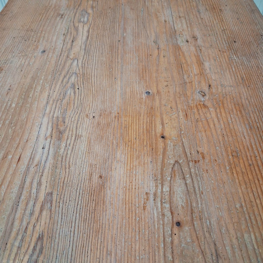 A long antique pine dining table featuring a solid plank top, deep side apron, and four tapered square legs. View VI