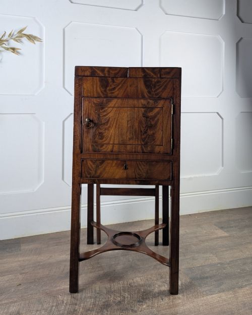 fig 1. A Georgian Cuban mahogany fold-away washstand featuring an upright mirror, opened side leaves, a central cupboard, a lower drawer, and an X-frame stretcher.