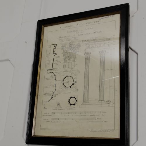 fig 2. A framed architectural illustration depicting technical drawings of the Corinthian order column, enclosed within a black wooden frame featuring gold trim.