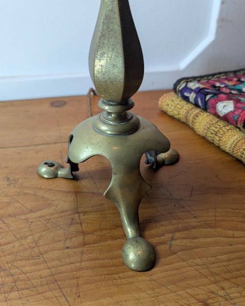 fig 1. An antique brass table lamp featuring a hexagonal baluster stem resting on a three-legged cast base.