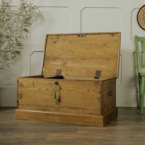 fig 1. A rectangular Victorian pitch pine storage trunk featuring visible dovetail joinery, an iron keyhole escutcheon, metal side handles, and a plinth base.