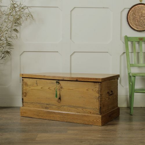 fig 2. A rectangular Victorian pitch pine storage trunk featuring visible dovetail joinery, an iron keyhole escutcheon, metal side handles, and a plinth base.