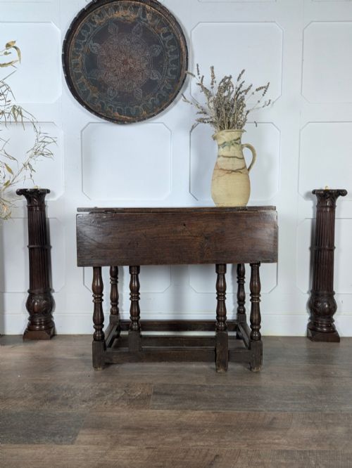 fig 1. An eighteenth-century dark oak gateleg table with drop leaves, turned legs, stretchers, and a single end drawer.