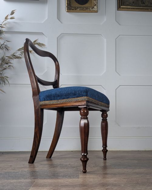fig 1. A Victorian rosewood side chair with a curved kidney backrest, turned front legs, and a navy blue velvet upholstered seat.