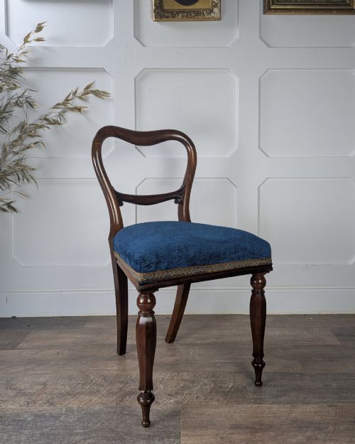fig 2. A Victorian rosewood side chair with a curved kidney backrest, turned front legs, and a navy blue velvet upholstered seat.