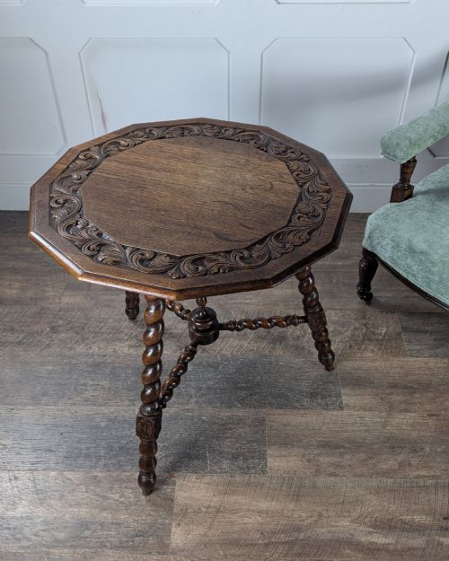fig 1. A late Victorian solid dark oak side table with an octagonal top, three barley twist legs, carved block knees, and a central turned finial on the stretcher base.