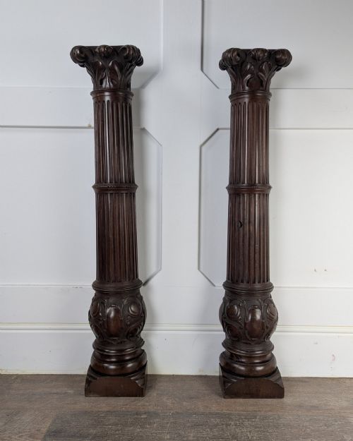 fig 1. A pair of dark carved mahogany half columns featuring Corinthian capitals, reeded shafts, and carved bulbous bases.