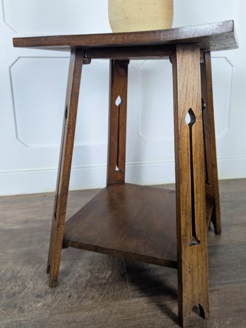 fig 1. A solid oak Art Nouveau side table featuring splayed legs with spade-shaped cutouts and a lower square undertier shelf.