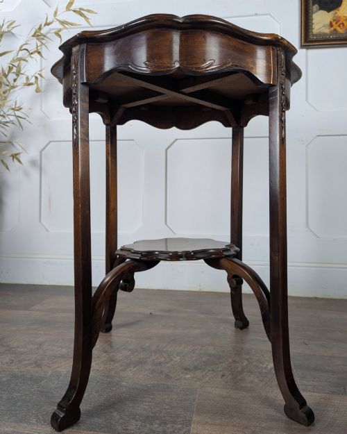 fig 1. An early 20th-century walnut side table featuring a scalloped rim, carved legs, and a lower undertier shelf.