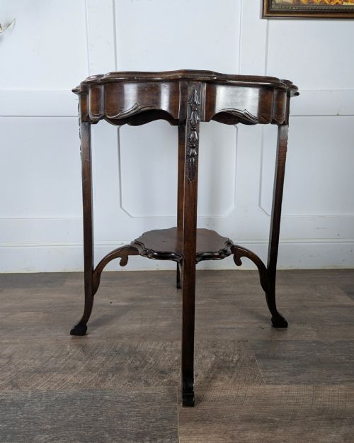 fig 2. An early 20th-century walnut side table featuring a scalloped rim, carved legs, and a lower undertier shelf.