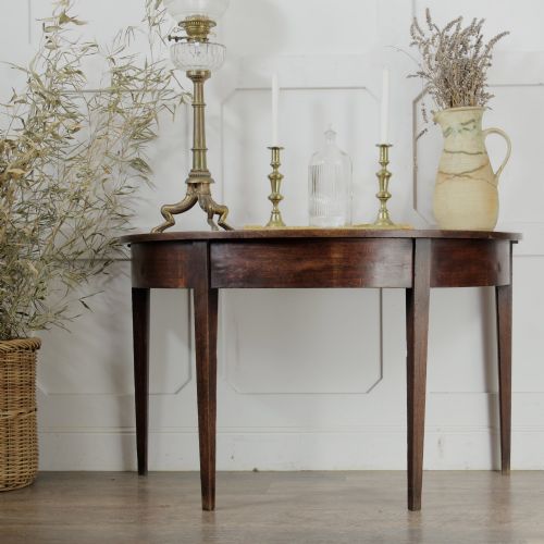 fig 2. A pair of Georgian walnut demilune tables placed together to form a single round top with tapered legs.