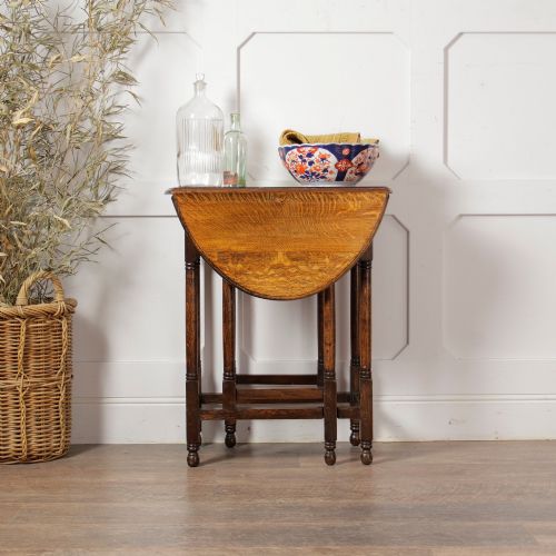 fig 1. A small oak gateleg side table with turned legs, drop-down side flaps, and a warm brown wood finish.