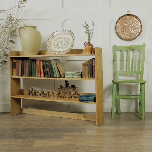 fig 1. A low three-tier vintage pine open-backed bookshelf with natural timber grain and knots visible throughout.