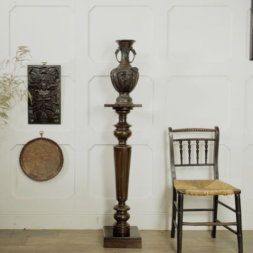 fig 1. A dark turned mahogany plinth stand featuring a square top and base with a fluted central column.