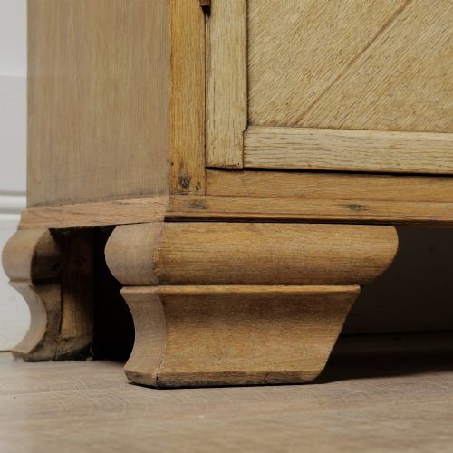 fig 1. An early twentieth-century mellow oak glazed bookcase featuring twin glass-fronted doors over a lower cupboard with diagonal grain panels.