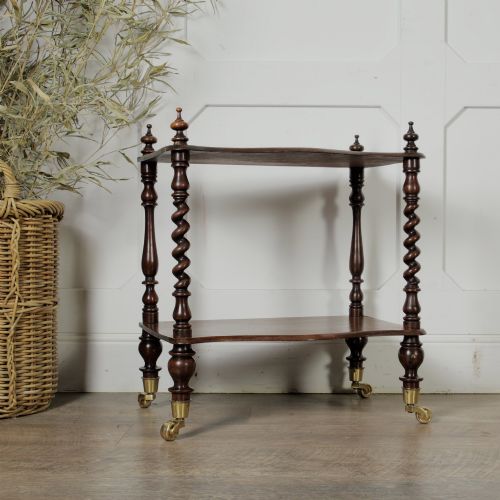 fig 1. A dark wood Victorian two-tier whatnot featuring hand-turned barley twist legs, top corner finials, and brass casters.