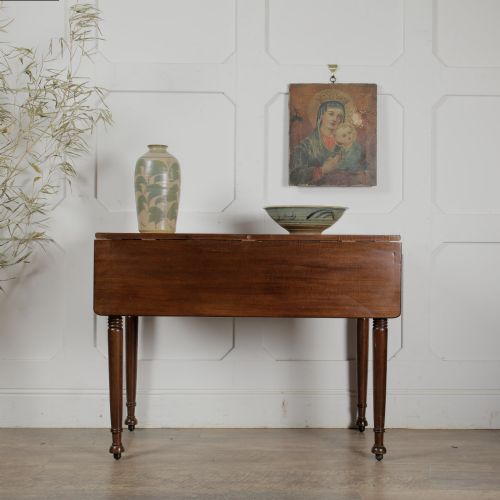 fig 1. A Victorian mahogany drop-leaf table featuring a single hinged flap, turned legs, and small wheel castors.