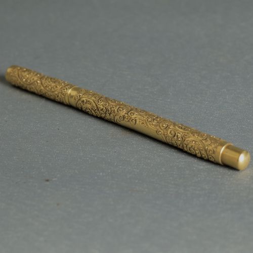 fig 1. An antique Mabie Todd Swan fountain pen with a detailed chased rolled gold barrel, unscrewed cap, and dark ebonite section with exposed nib.