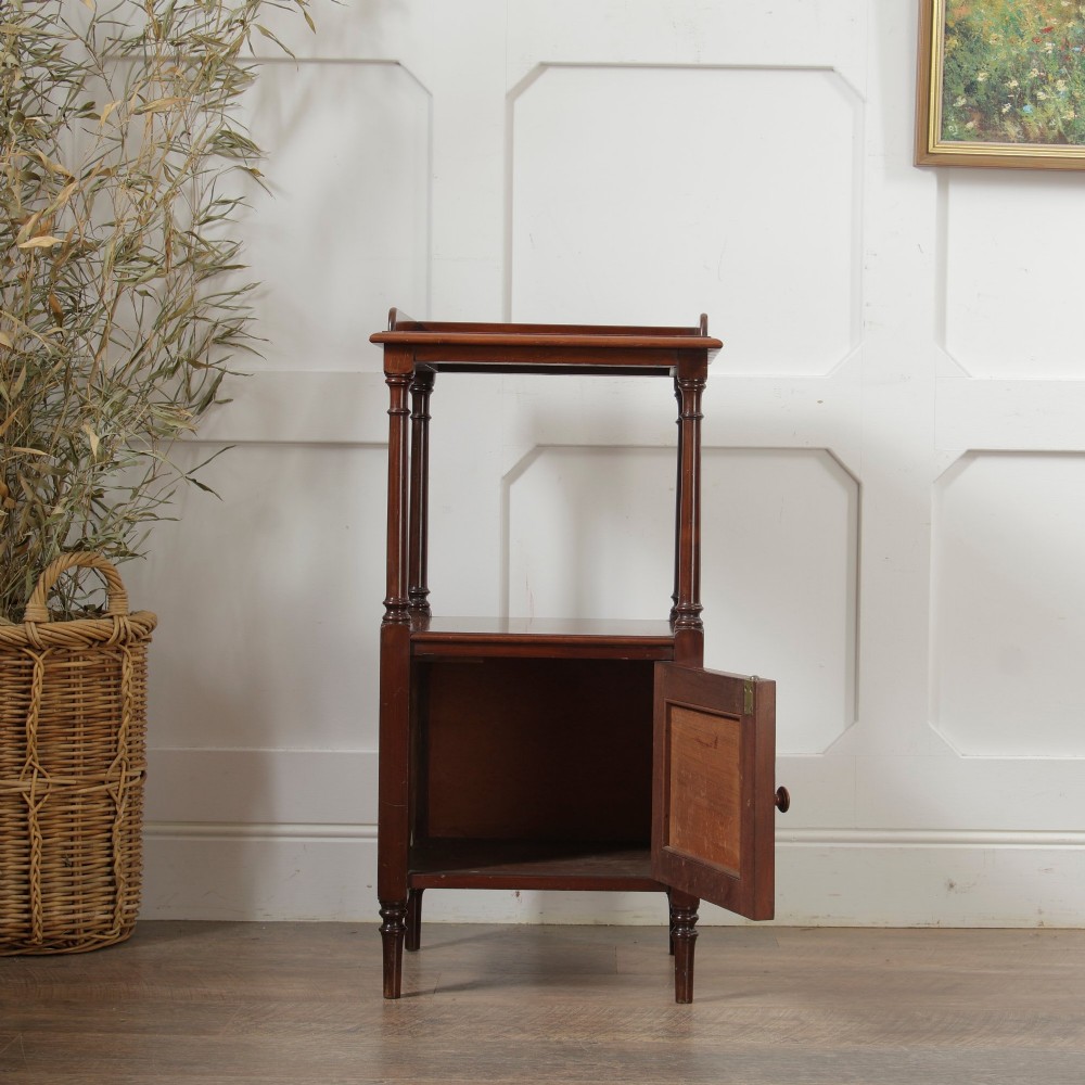 A Victorian mahogany pot cupboard with an open upper shelf supported by turned columns, sitting above a single-door cupboard adorned with a central marquetry inlay. View IV