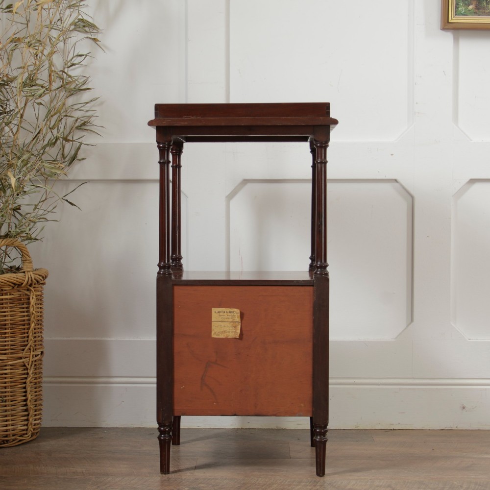 A Victorian mahogany pot cupboard with an open upper shelf supported by turned columns, sitting above a single-door cupboard adorned with a central marquetry inlay. View VII