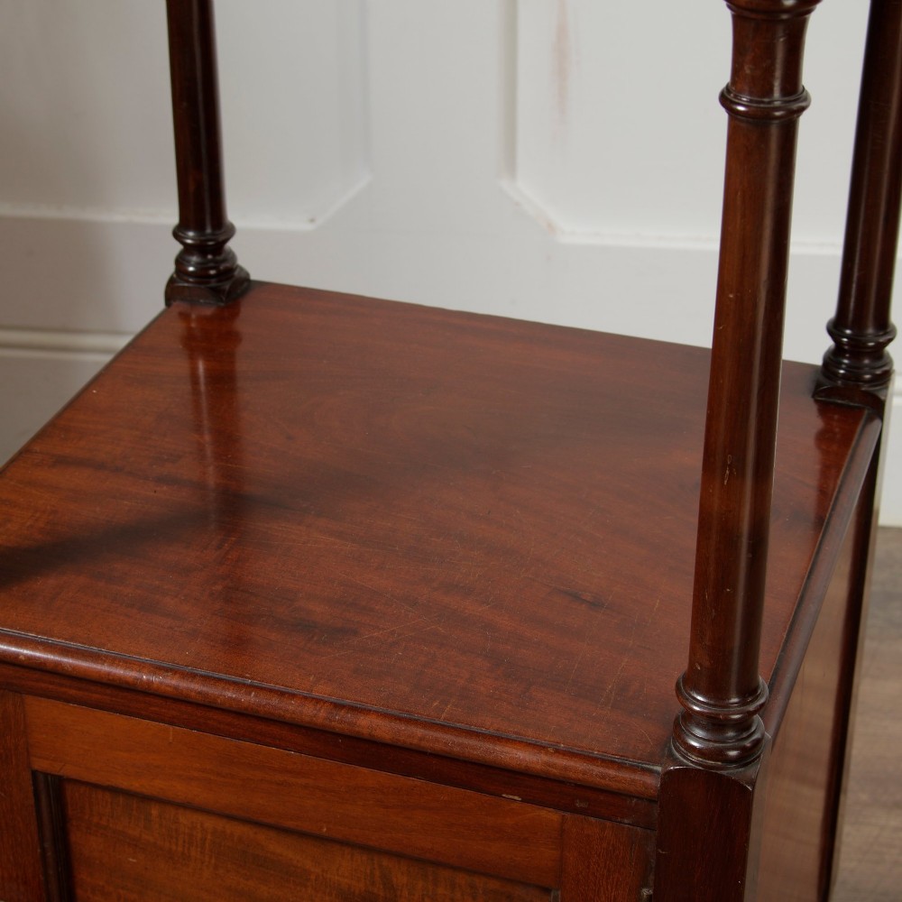 A Victorian mahogany pot cupboard with an open upper shelf supported by turned columns, sitting above a single-door cupboard adorned with a central marquetry inlay. View IX