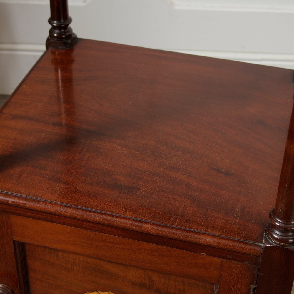 A Victorian mahogany pot cupboard with an open upper shelf supported by turned columns, sitting above a single-door cupboard adorned with a central marquetry inlay. View XI