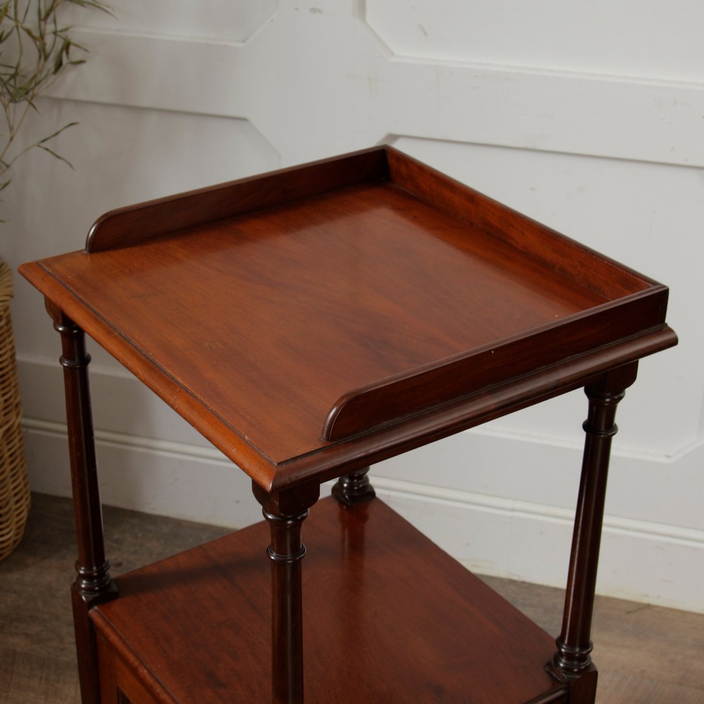 A Victorian mahogany pot cupboard with an open upper shelf supported by turned columns, sitting above a single-door cupboard adorned with a central marquetry inlay. View XV