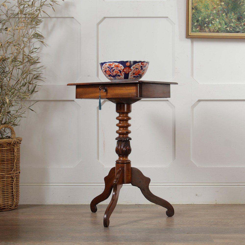A Victorian mahogany pedestal table featuring a square top with a drawer, a central bobbin-turned stem, and a carved tripod base.