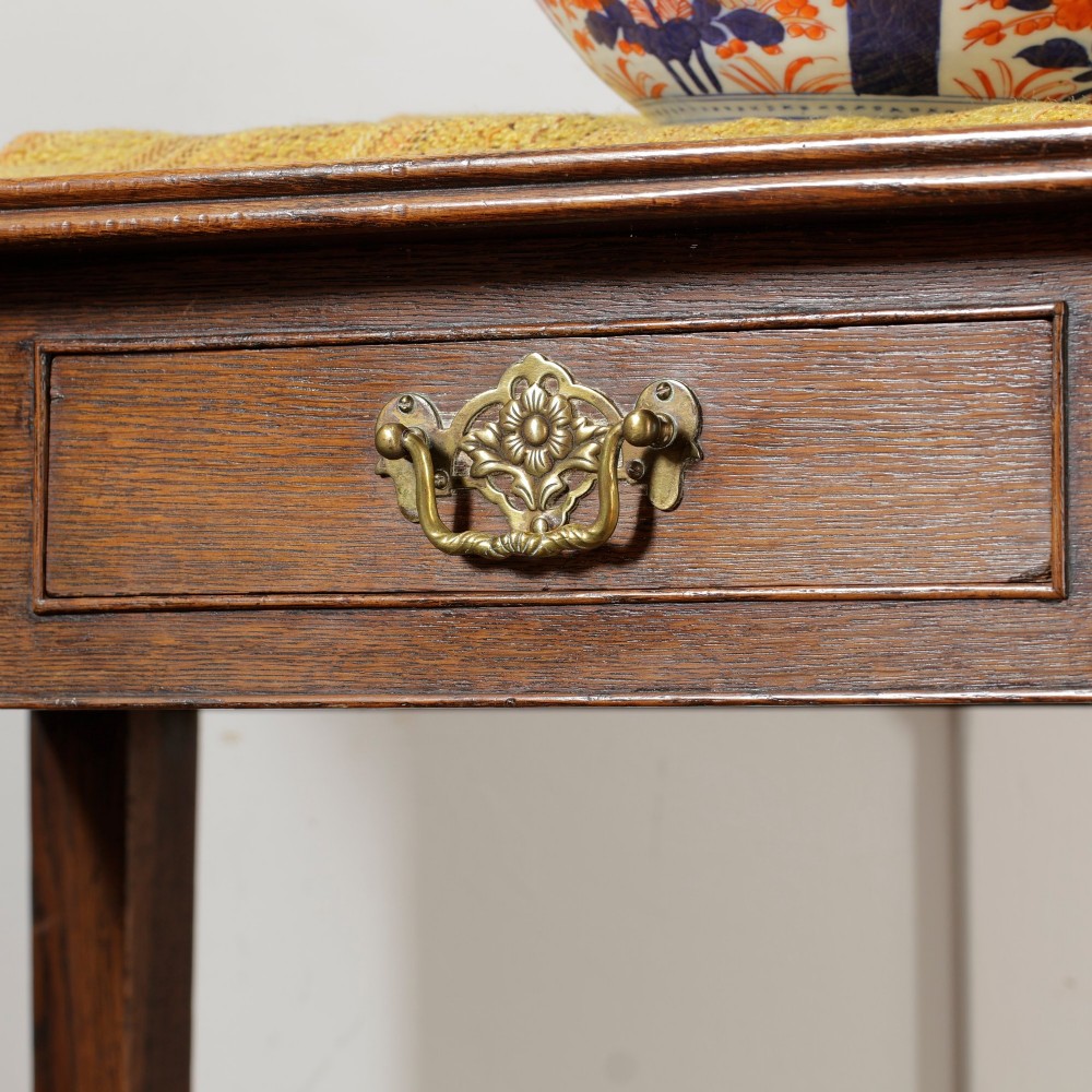 A George III Georgian oak side table featuring a single drawer with a brass handle plate and four square tapered legs. View III