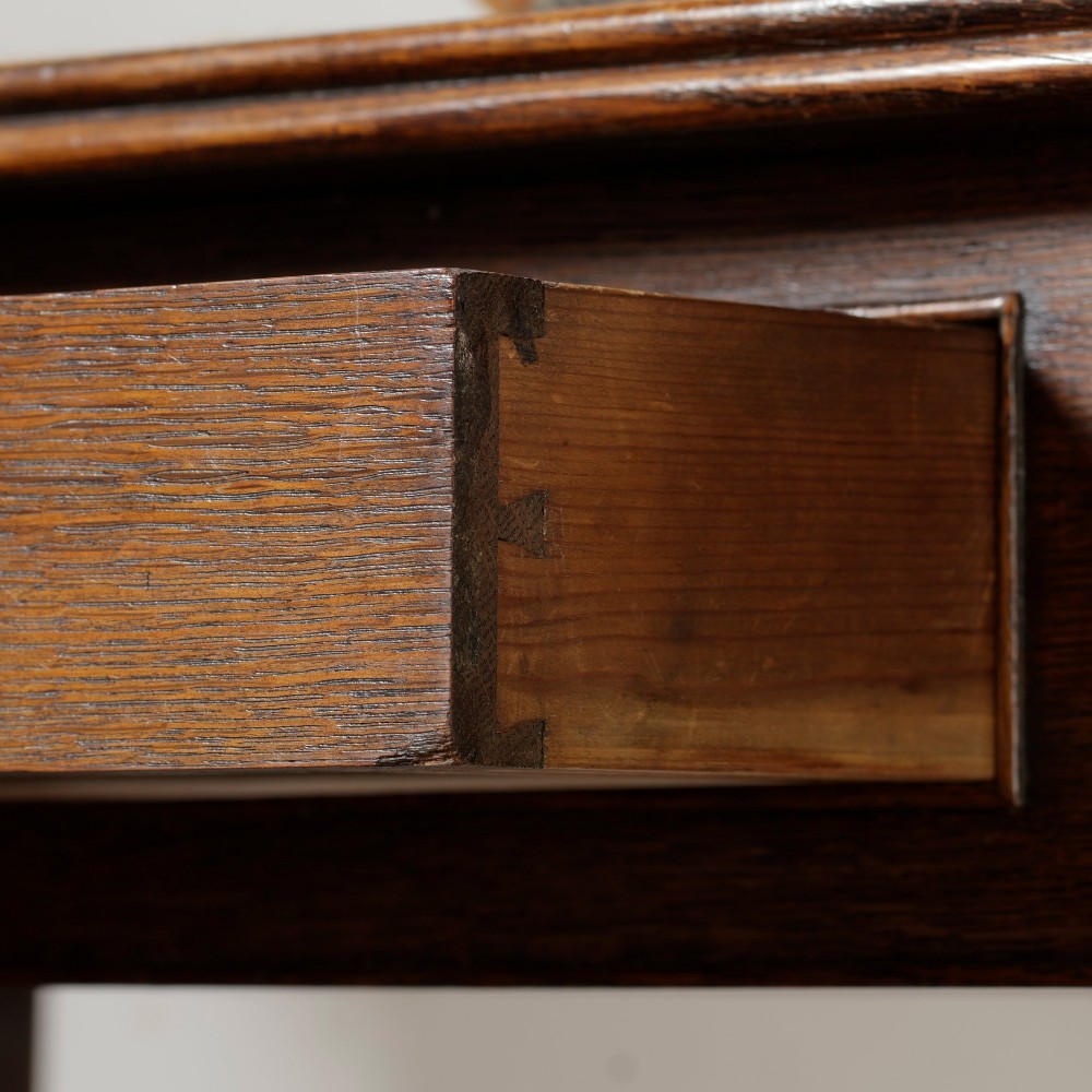A George III Georgian oak side table featuring a single drawer with a brass handle plate and four square tapered legs. View VI