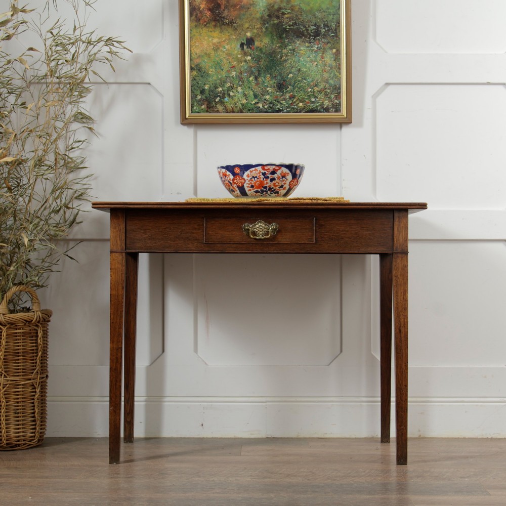 A George III Georgian oak side table featuring a single drawer with a brass handle plate and four square tapered legs. View XII
