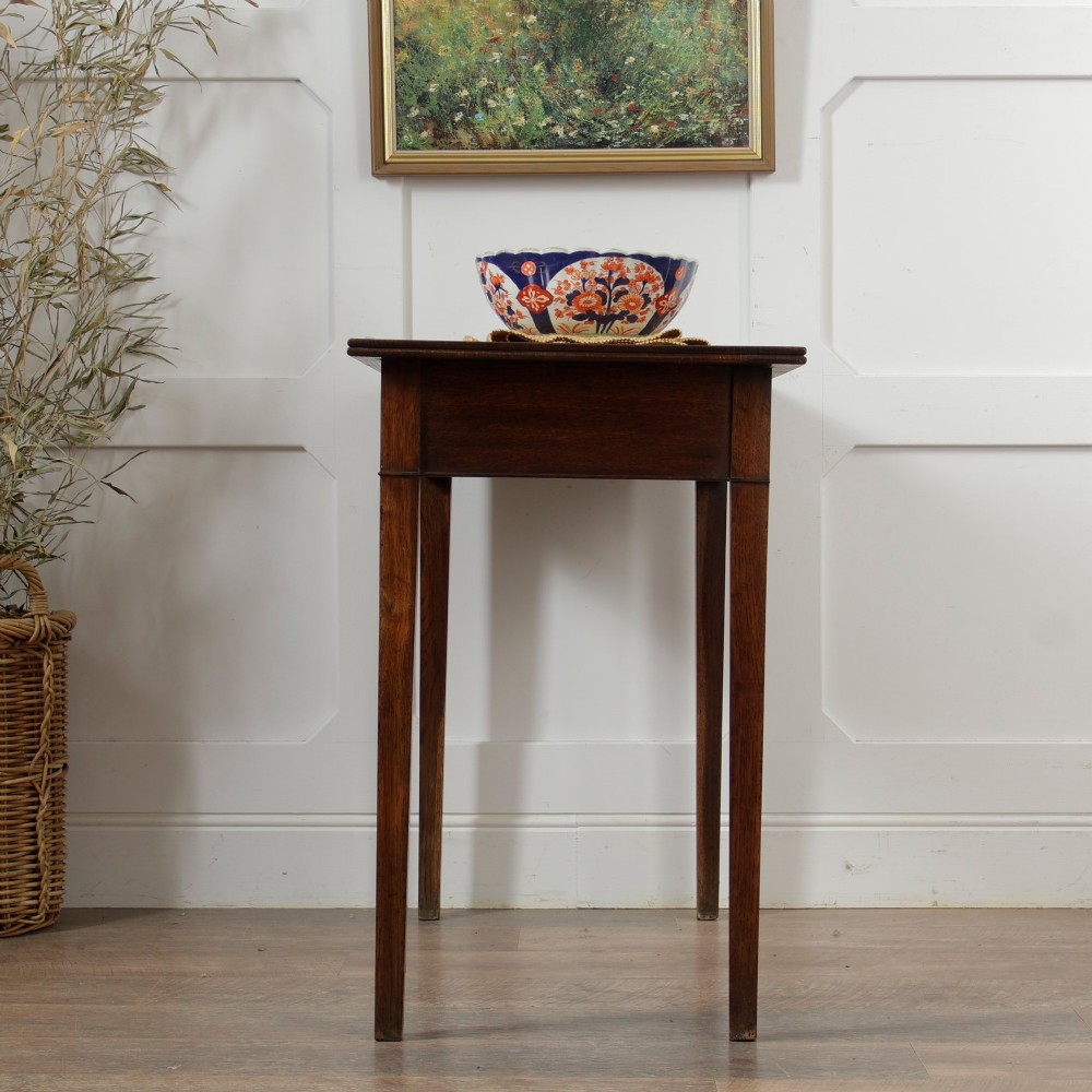 A George III Georgian oak side table featuring a single drawer with a brass handle plate and four square tapered legs. View XIII