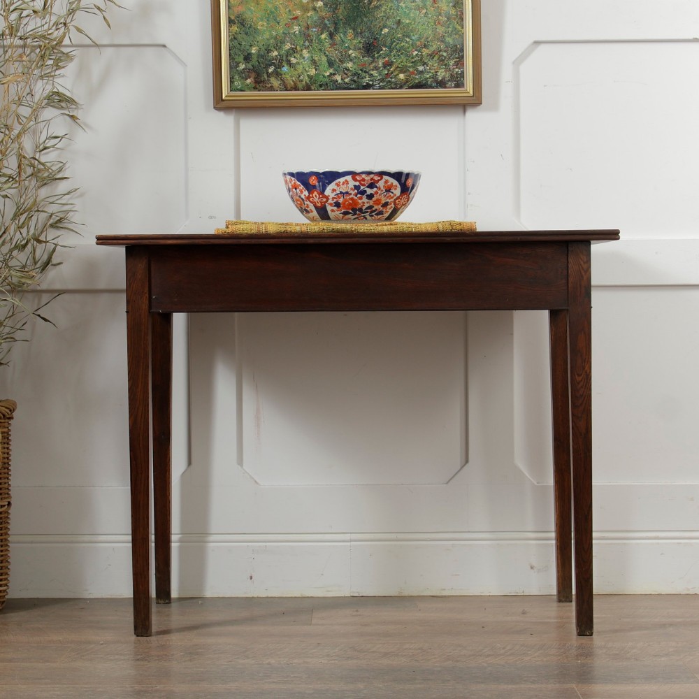A George III Georgian oak side table featuring a single drawer with a brass handle plate and four square tapered legs. View XIV