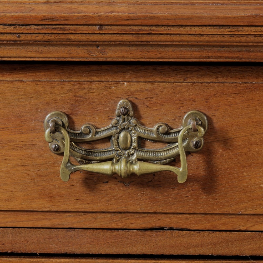 A late Victorian wooden glazed bookcase featuring two upper glass doors above two drawers and a double-door cupboard carved with floral urn motifs. View VII