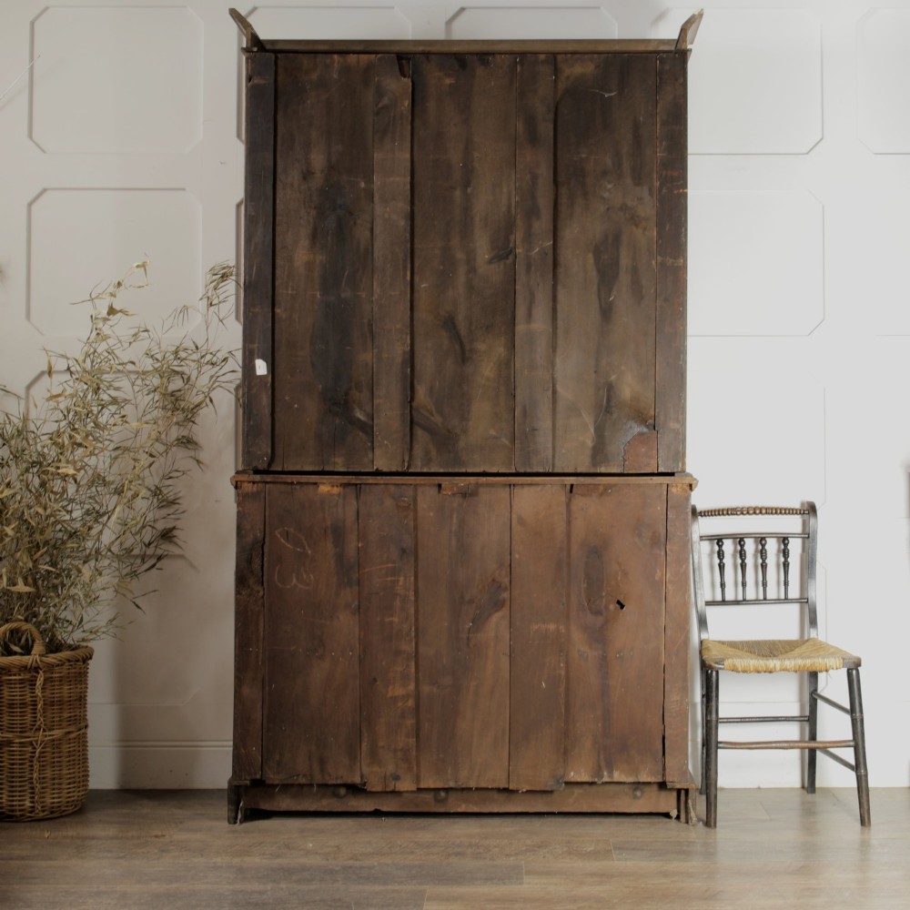 A late Victorian wooden glazed bookcase featuring two upper glass doors above two drawers and a double-door cupboard carved with floral urn motifs. View XV