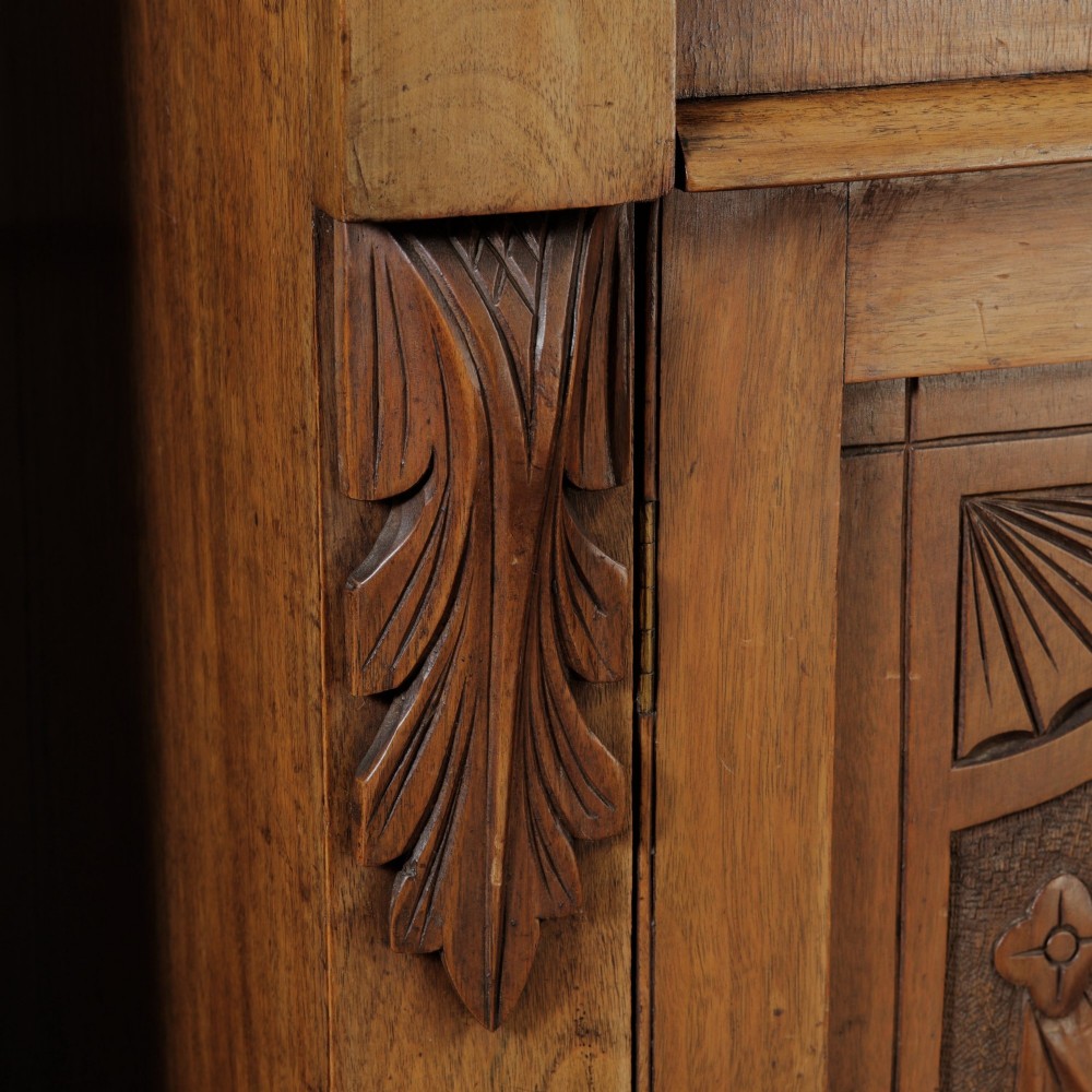 A mid-Victorian mahogany bookcase featuring a two-door glazed upper section, a single frieze drawer, and a lower cupboard with carved panel doors. View VII