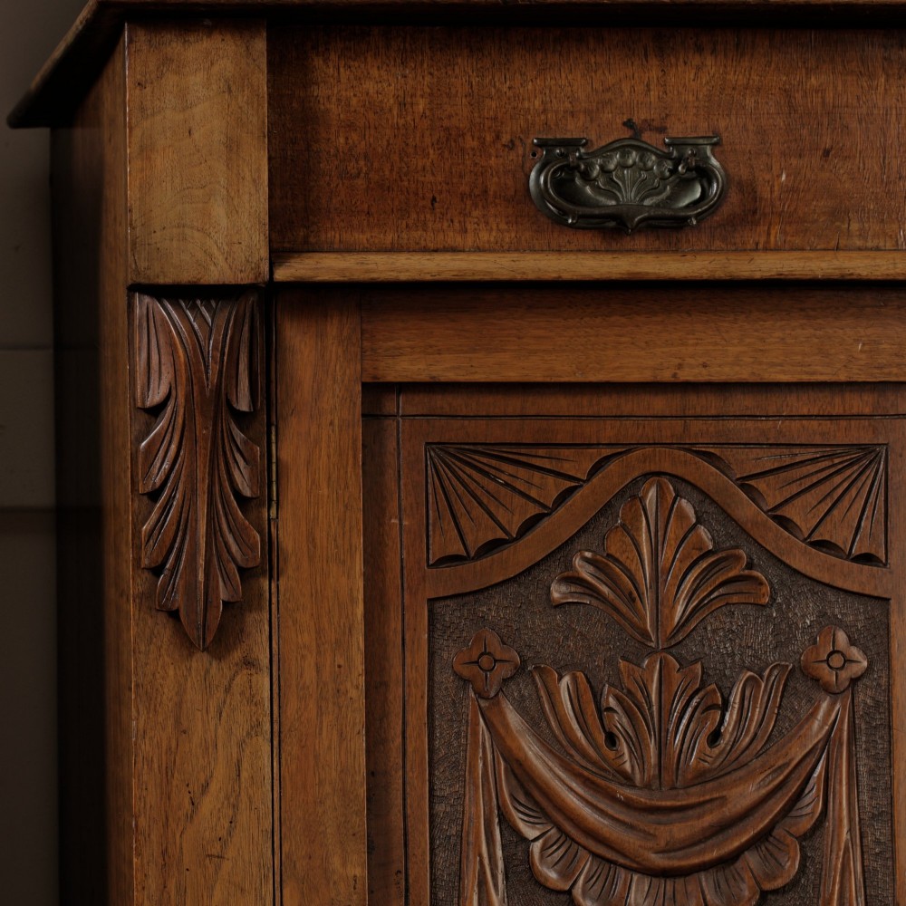 A mid-Victorian mahogany bookcase featuring a two-door glazed upper section, a single frieze drawer, and a lower cupboard with carved panel doors. View XII