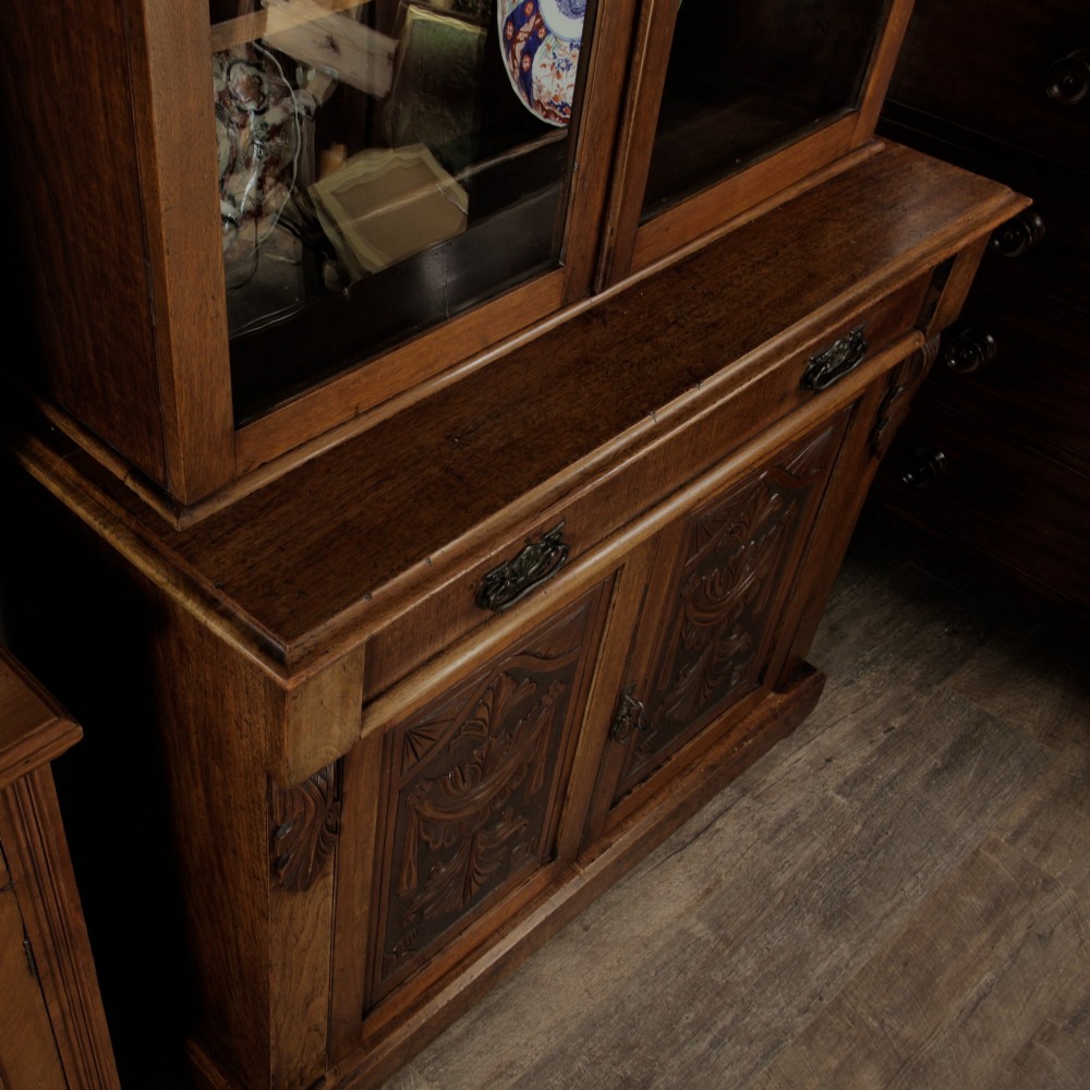 A mid-Victorian mahogany bookcase featuring a two-door glazed upper section, a single frieze drawer, and a lower cupboard with carved panel doors. View XIV
