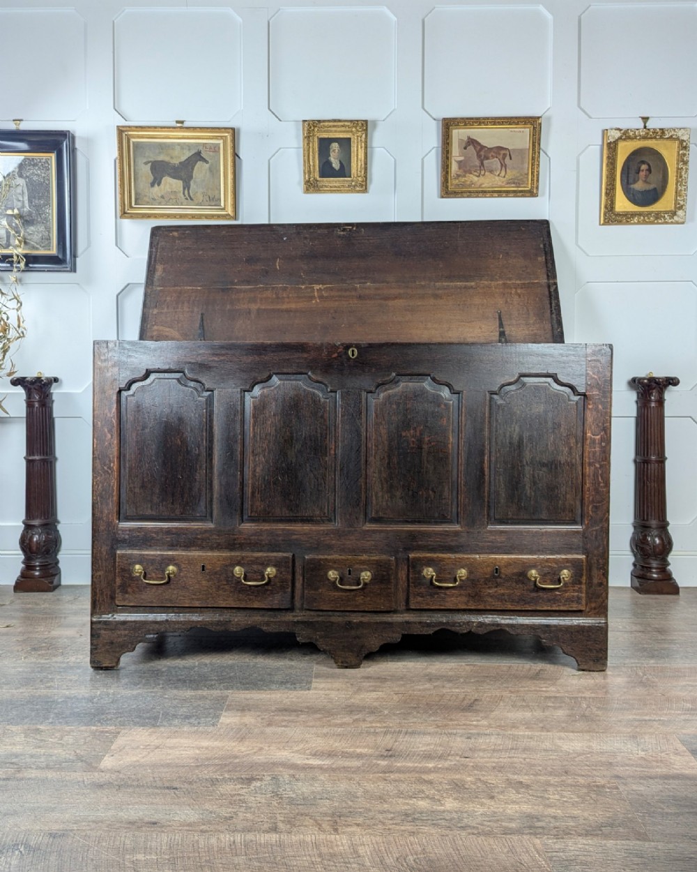 An 18th-century dark oak mule chest featuring four fielded front panels above three small drawers with brass handles. View II