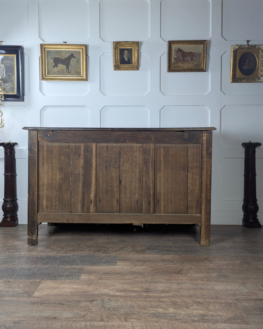 An 18th-century dark oak mule chest featuring four fielded front panels above three small drawers with brass handles. View V