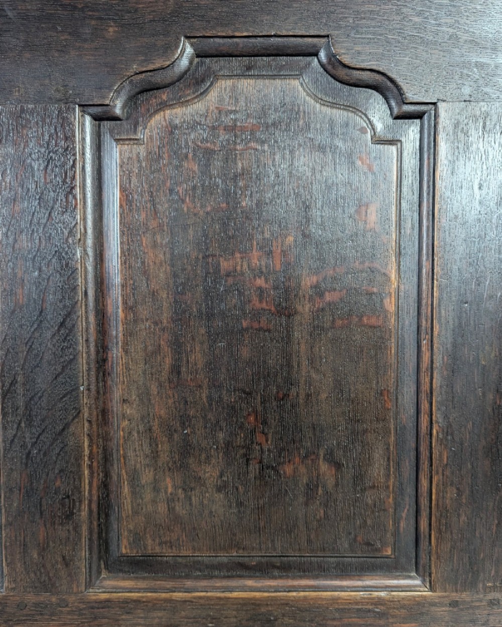An 18th-century dark oak mule chest featuring four fielded front panels above three small drawers with brass handles. View X