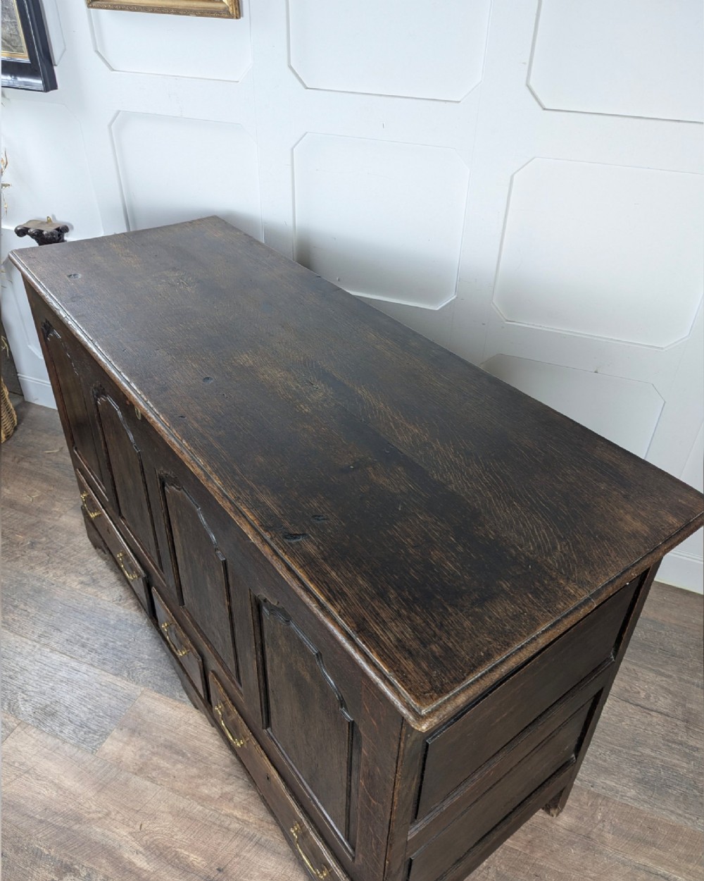 An 18th-century dark oak mule chest featuring four fielded front panels above three small drawers with brass handles. View XII