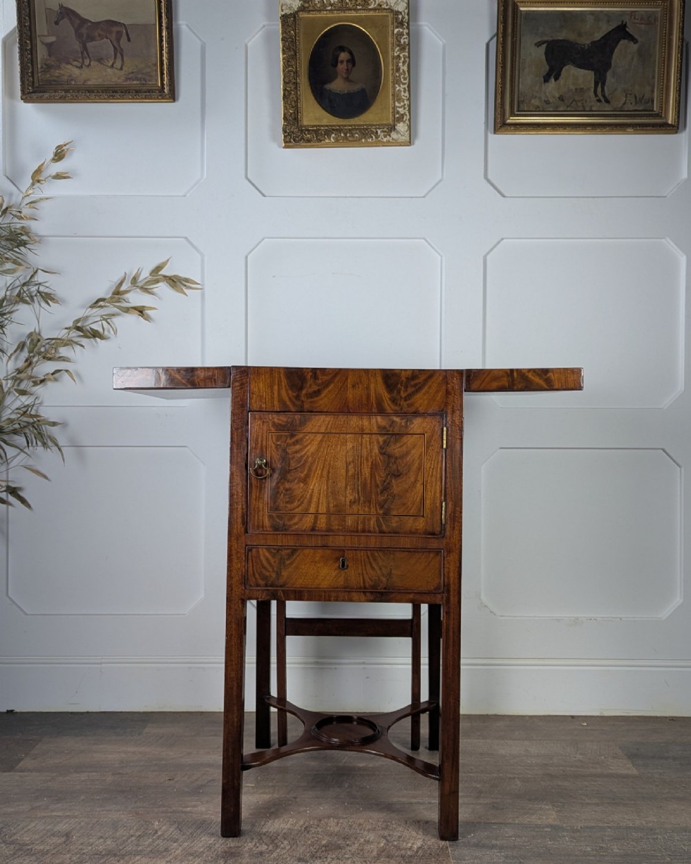 A Georgian Cuban mahogany fold-away washstand featuring an upright mirror, opened side leaves, a central cupboard, a lower drawer, and an X-frame stretcher. View VII