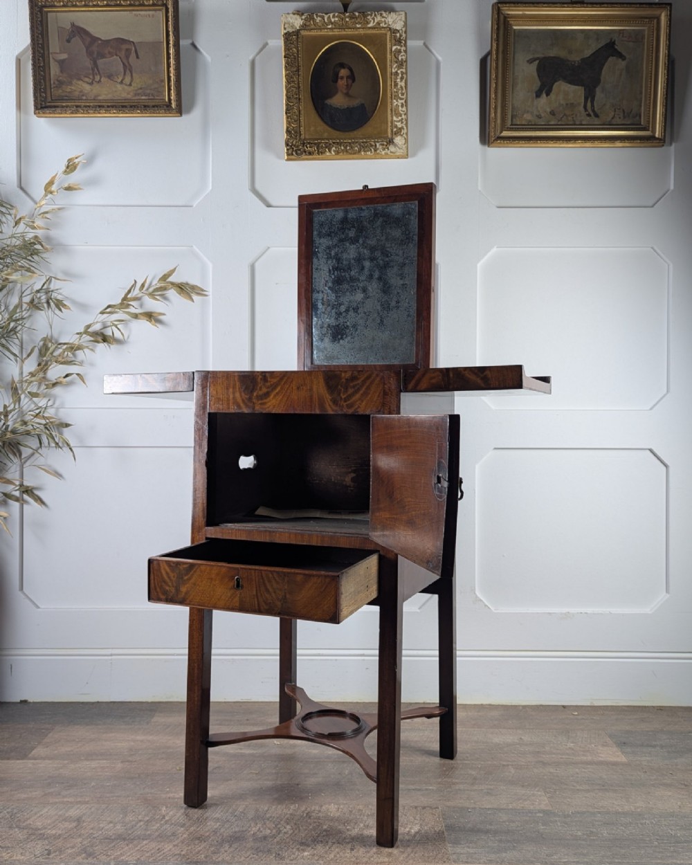 A Georgian Cuban mahogany fold-away washstand featuring an upright mirror, opened side leaves, a central cupboard, a lower drawer, and an X-frame stretcher. View IX