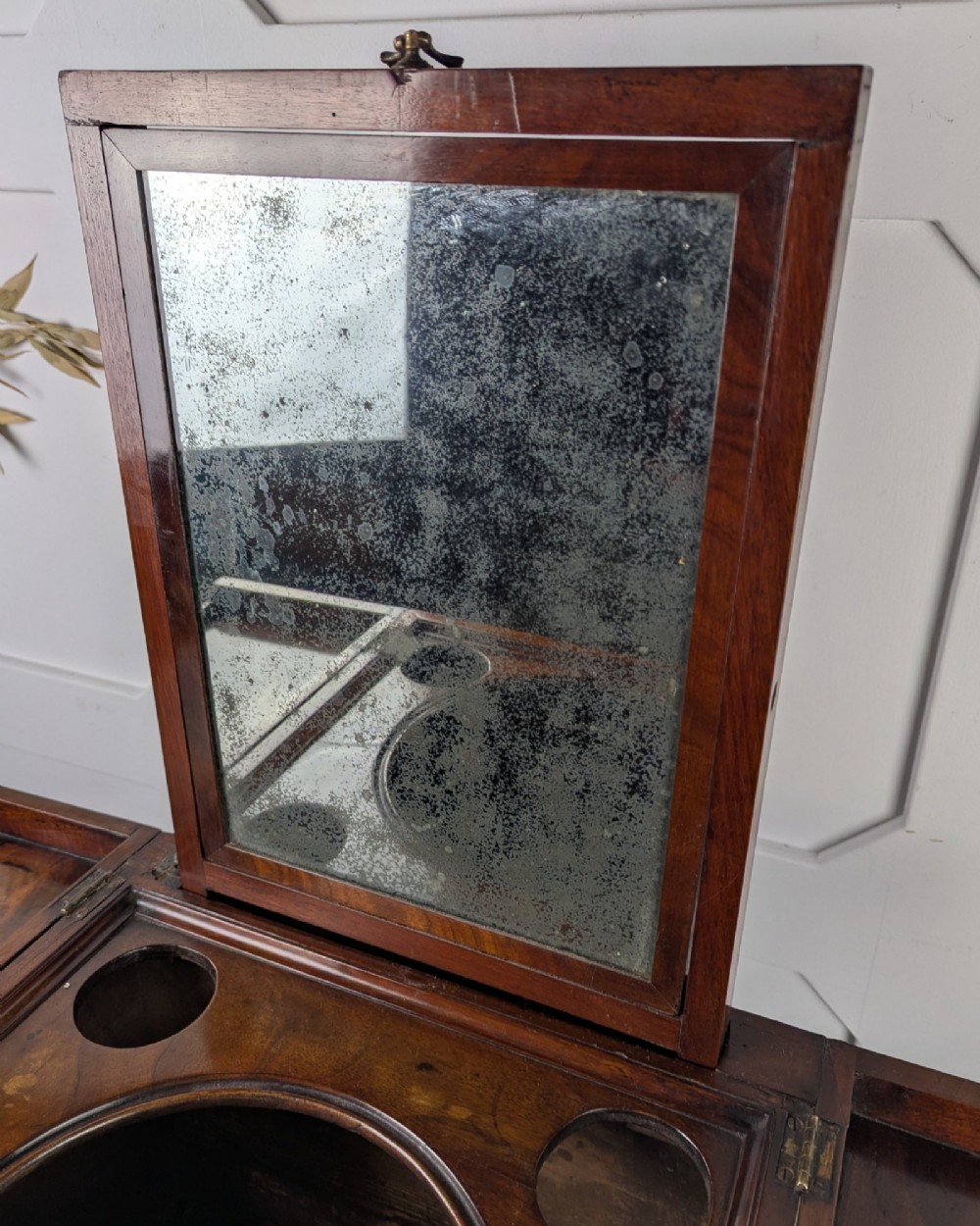 A Georgian Cuban mahogany fold-away washstand featuring an upright mirror, opened side leaves, a central cupboard, a lower drawer, and an X-frame stretcher. View XIII