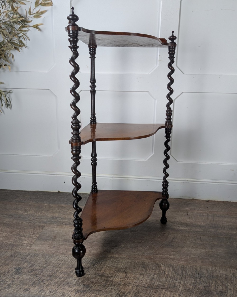 A Victorian dark mahogany three-tier corner whatnot featuring spiralled barley twist front supports and finial details. View V