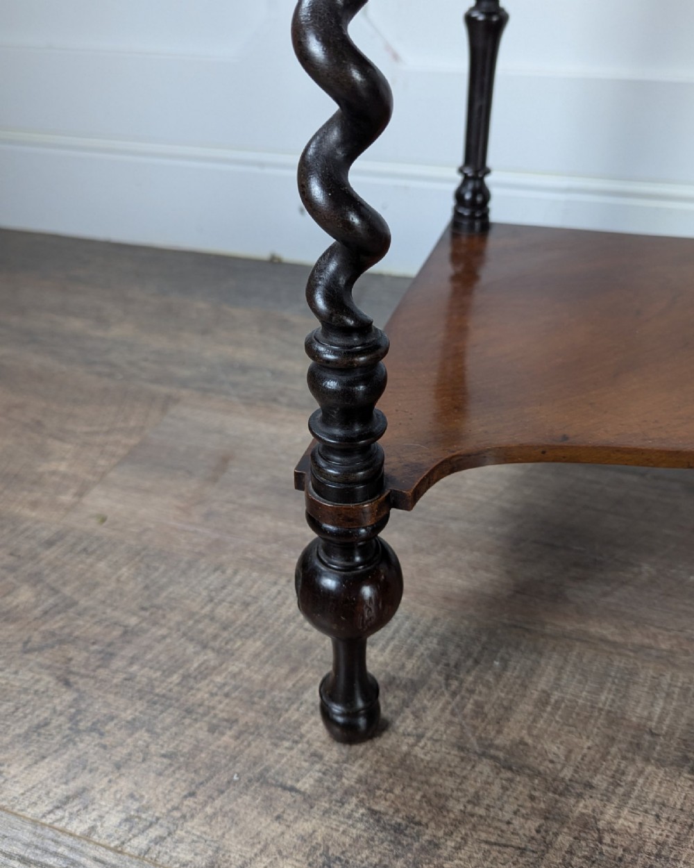 A Victorian dark mahogany three-tier corner whatnot featuring spiralled barley twist front supports and finial details. View VII