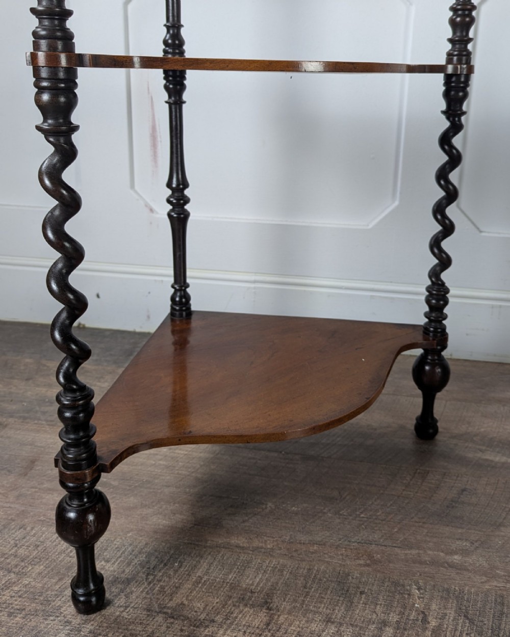 A Victorian dark mahogany three-tier corner whatnot featuring spiralled barley twist front supports and finial details. View VIII