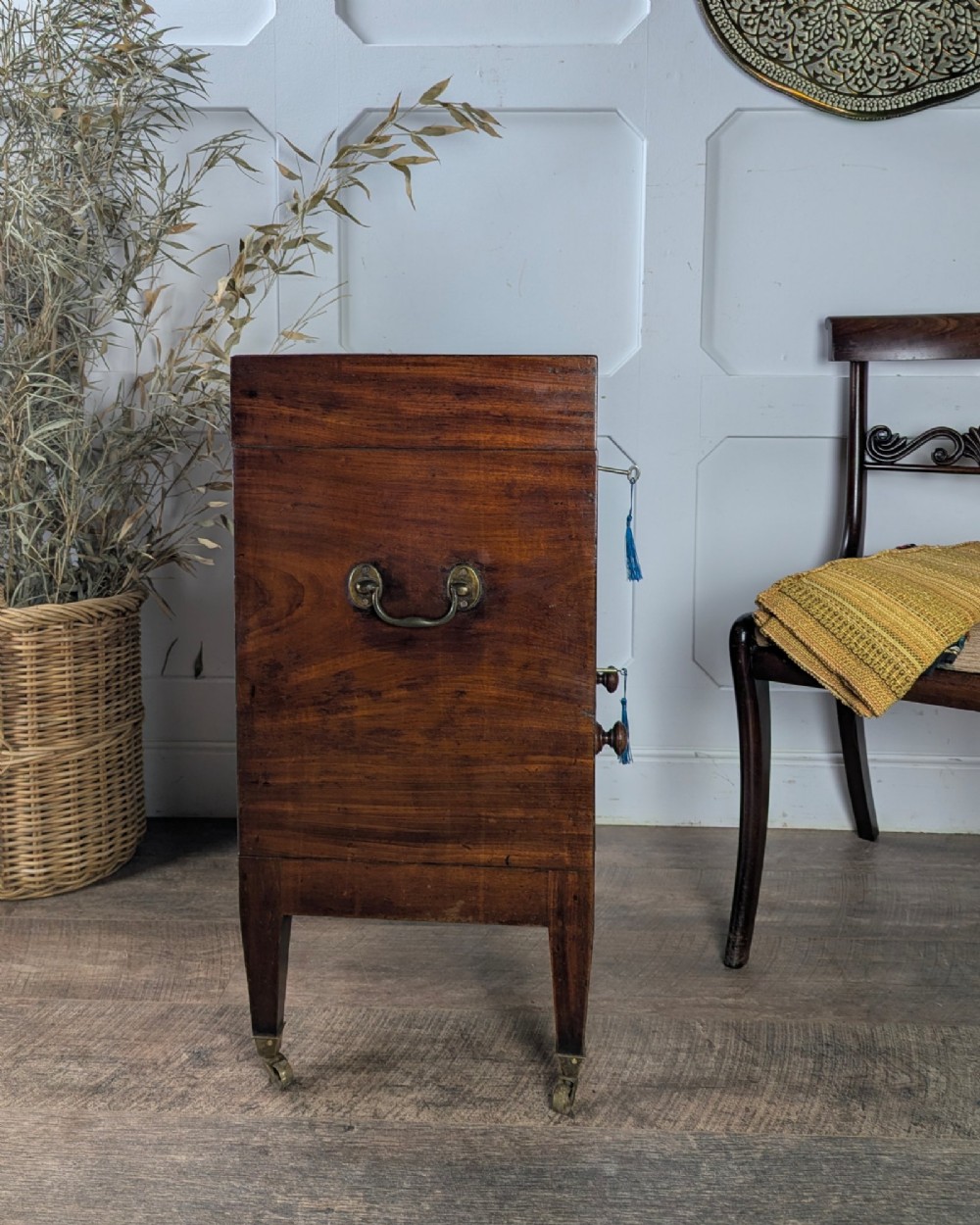 A Georgian dark mahogany cellarette featuring a hinged top lid, a lower drawer with wooden turned knobs, brass side handles, and square tapered legs on brass castors. View II